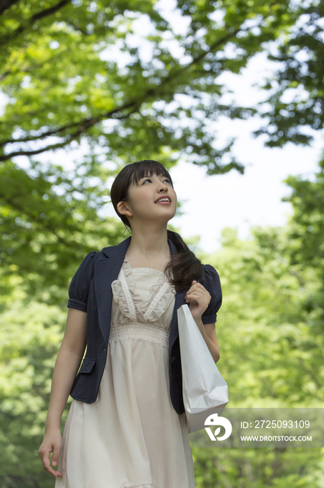 Young woman walking with shopping bag