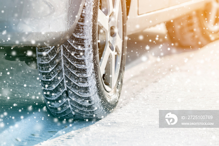 Close-up of car wheels rubber tires in deep winter snow. Transportation and safety concept.