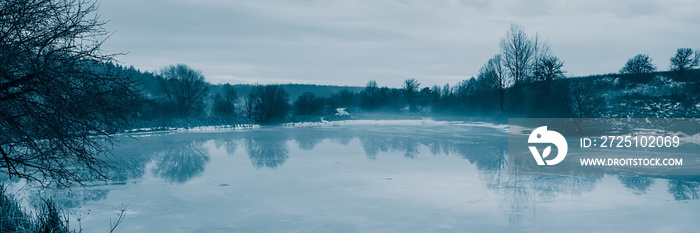 Frozen pond, thaw. Winter season in the countryside.