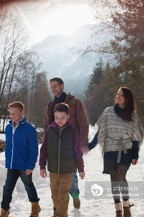 Family walking on sunny snowy footpath