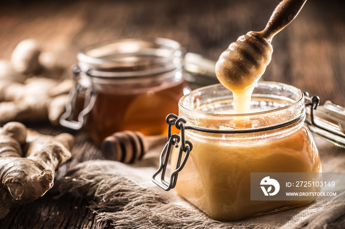 Honey in jars and  dipper on rustic oak table