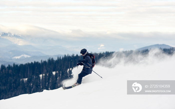 与滑雪者的全景照片，冬季山景。年轻人从白雪皑皑的山上滑雪下山