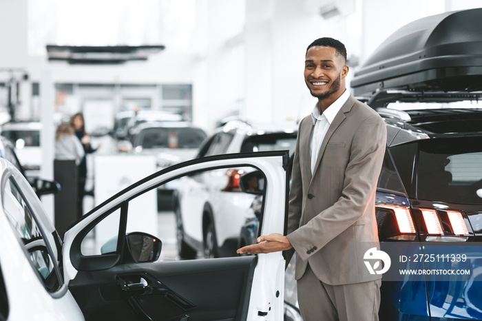 Dealer Showing New Automobile Opening Door Standing In Dealership Center