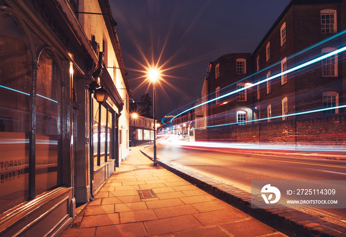 Harrow on the Hill by night with passing cars and buses in motion, England