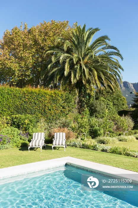 Lounge chairs at sunny luxury poolside