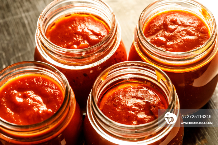 barattoli aperti di passata di pomodoro  disposti in fila