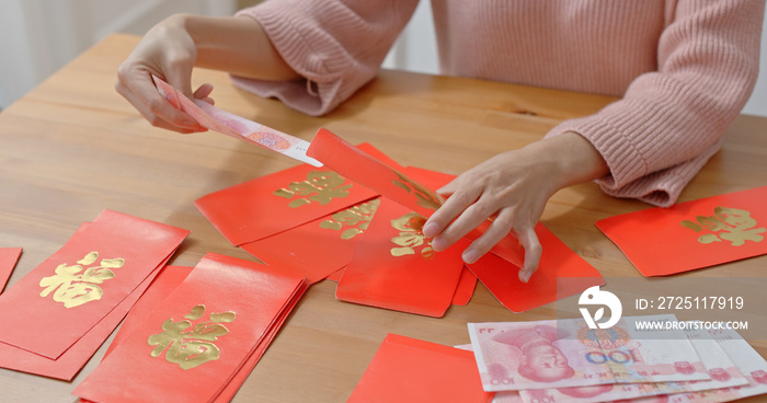 Woman fill money into red packet for lunar new year