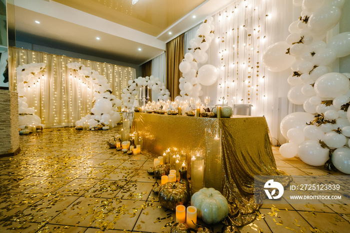 婚礼餐桌。婚礼装饰拱门。白色气球、蜡烛、秋叶