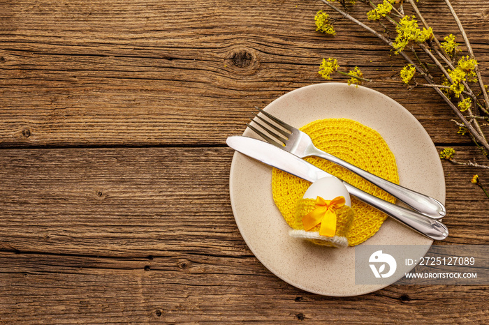 Easter table setting on old wooden background. Spring holiday card template. Cutlery, crochet napkin