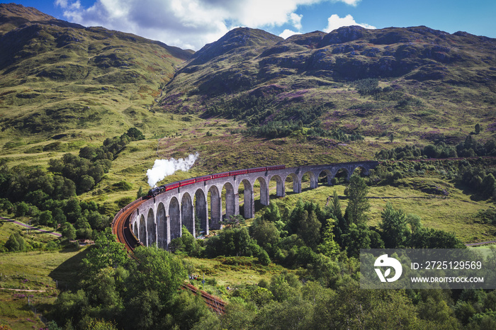 Glenfinnan Railway Viaduct in Scotland with the Jacobite steam train passing over.