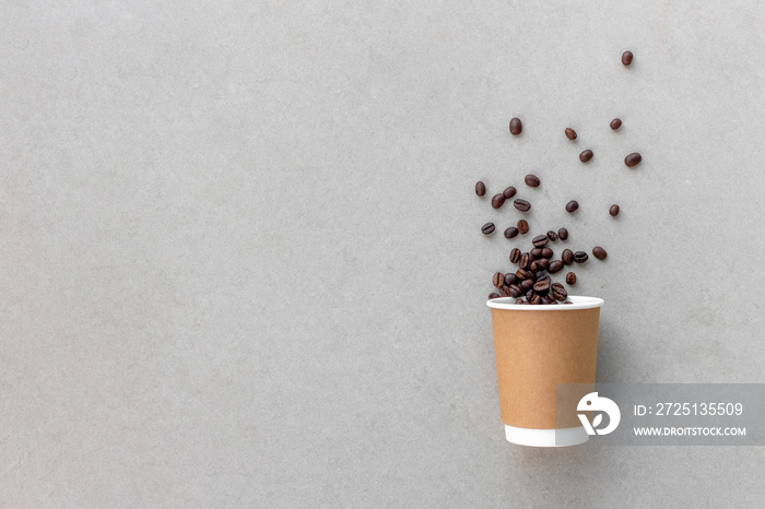 paper cup and coffee beans on cement floor background