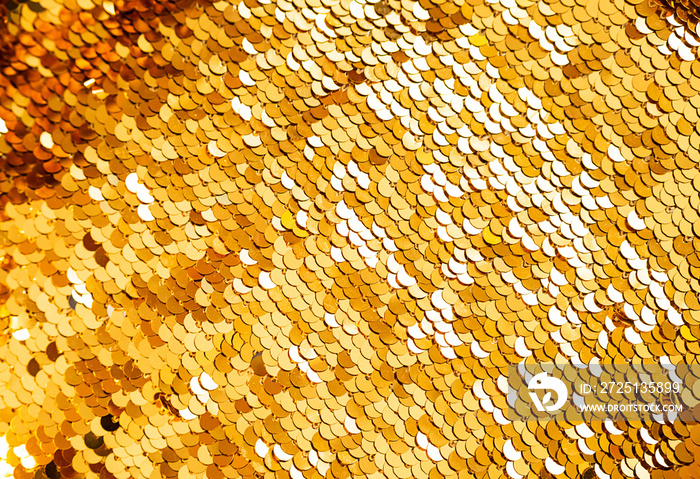 Golden sequins macro background. Sparkling sequined textile. Abstract texture scales with shiny sequ