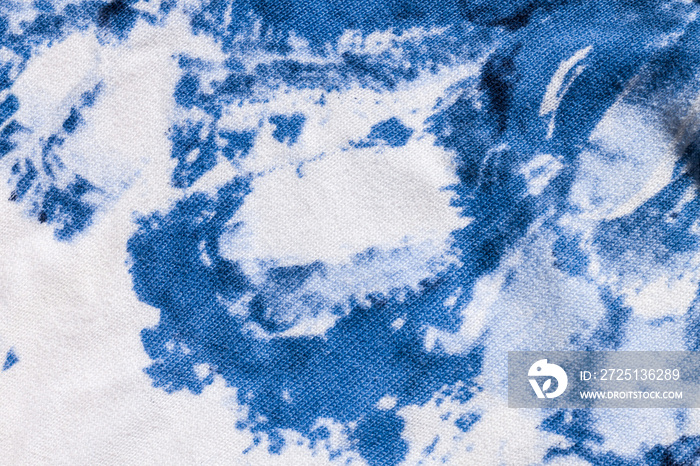Tie-dye cotton fabric texture blue and white paint colors. Ancient resist-dyeing textile coloring te
