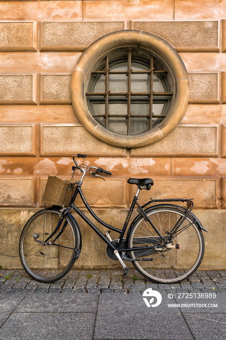 圆形窗户背景墙上的复古红色自行车