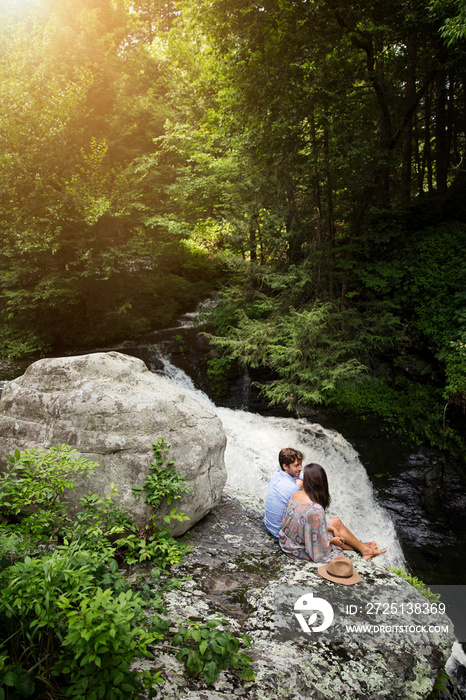 Young couple face to face by waterfall