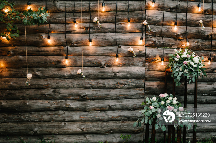 木制墙壁装饰花环，带发光灯泡和电灯装饰花朵。原创婚礼