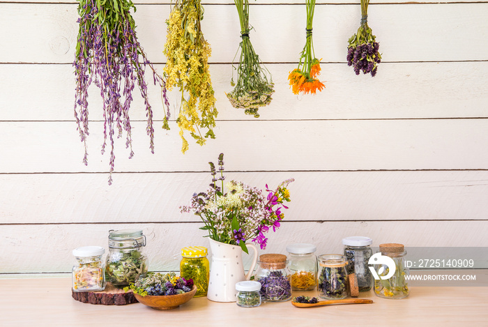 Lot of various herbal medicinal plants gathered and drying in room and dried herbs inside jars, lot 