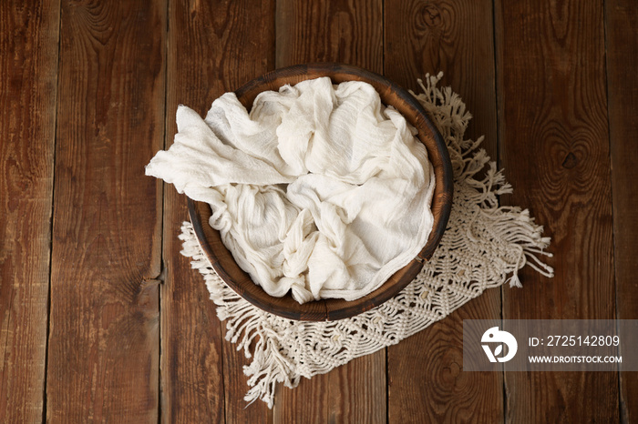 Newborn photography digital background prop. wicker basket with white fur on a wooden background.