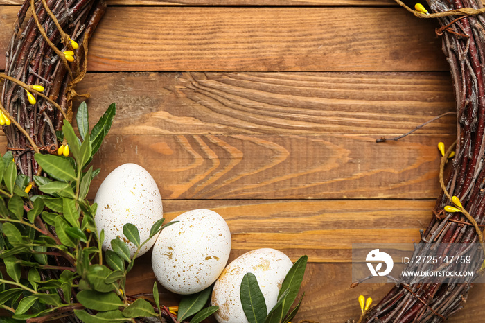 Beautiful Easter wreath and eggs on wooden background, closeup