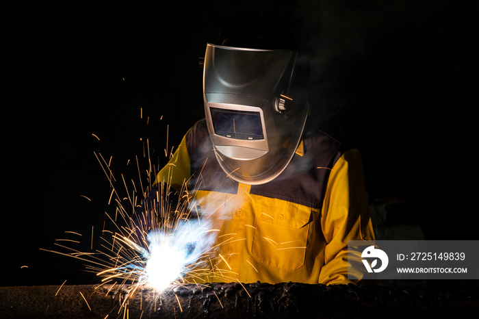 Worker welding a part of construction steel in his workshop, Welding and construction concept