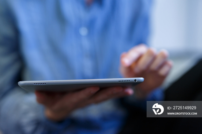 Frau mit Tablet Computer in der Hand. Benutzt Ipad mit Fingern auf Touchscreen  mit Hintergrund Unsc