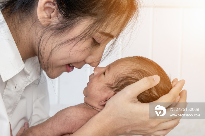 mother holding her infant baby boy on hand