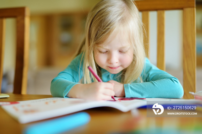可爱的女孩在日托中心用彩色铅笔画画。有创意的孩子在学校画画。女孩在做ho