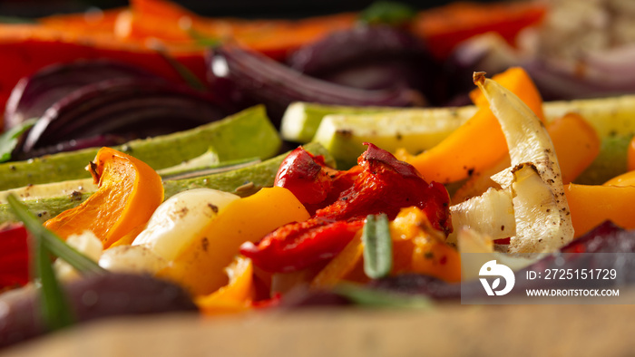 Stewed vegetables on a baking sheet, carrots with garlic and red onions,zucchini with bell pepper an