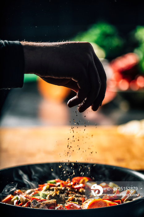 Seasoning - Chef Sprinkling Oregano over Vegetables