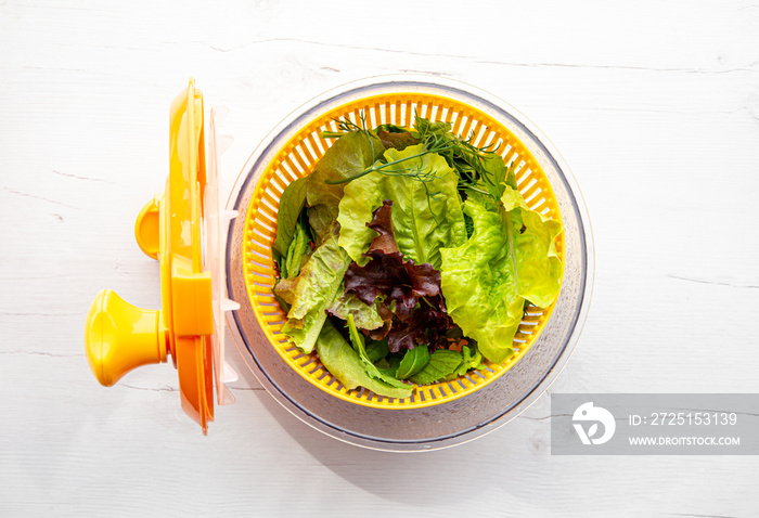 沙拉旋转工具碗的俯视图，里面有绿叶蔬菜。洗涤和干燥的舒适方式