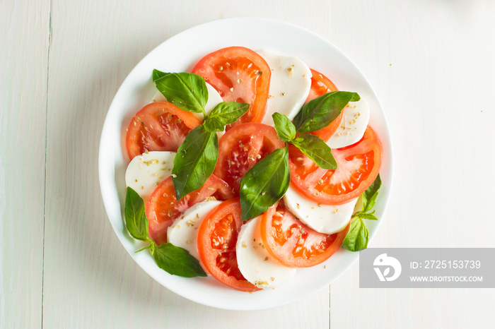 Close-up photo of caprese salad with ripe tomatoes, basil, buffalo mozzarella cheese. Italian and Me