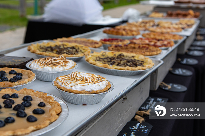 Baked goods at outdoor agriculture fair. Homemade traditional tarts are seen displayed on a stall du