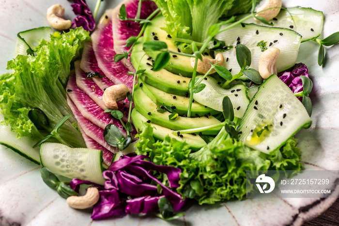 Salad from radish, avocado, microgreen, cabbage, cucumber and lettuce leaves. Vegan food. Dietary me