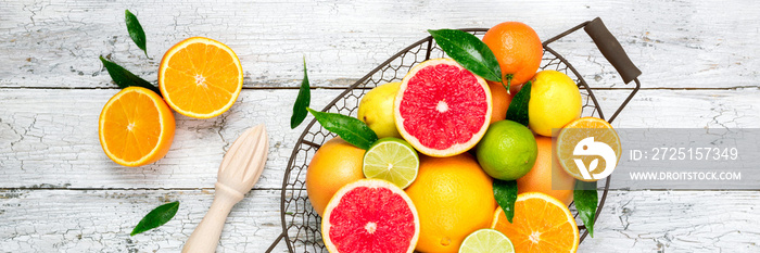 木桌上的柑橘类水果和烹饪柑橘汁。各种新鲜柑橘类水果与树叶。H