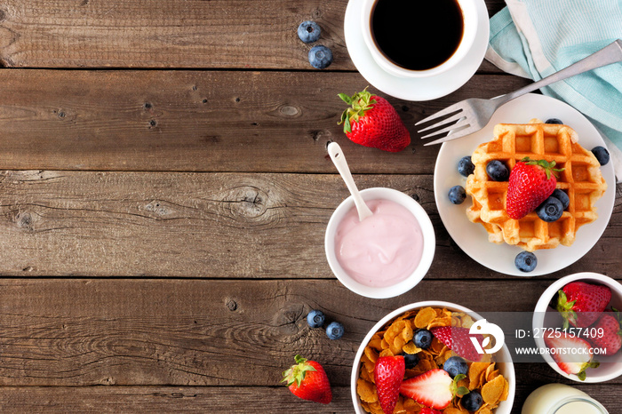 Breakfast food side border. Fruits, cereal, waffles, yogurt and coffee. Top view over a dark wood ba