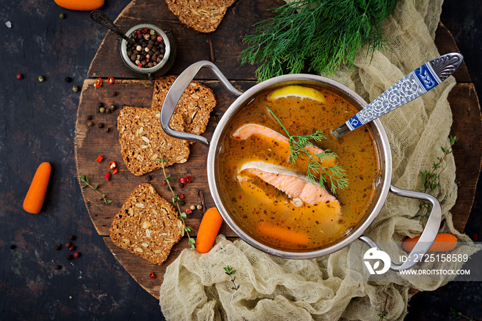 Salmon fish soup with vegetables in pan. Flat lay. Top view