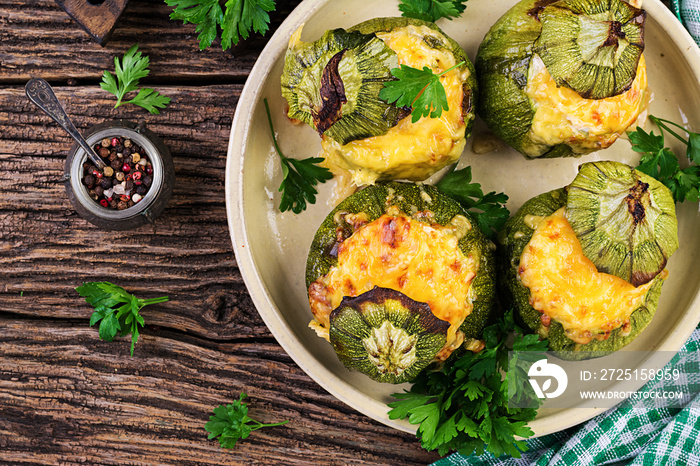 Zucchini stuffed with minced meat, cheese and green herbs. Baked in oven. Top view