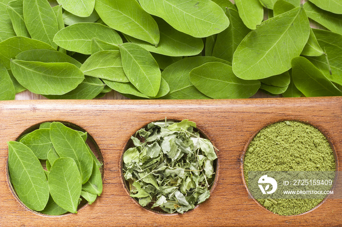 Leaves and moringa powder on wood (moringa oleifera)