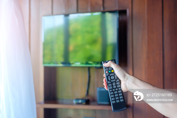 在家里或豪华酒店的现代化房间内手动调节智能电视的遥控器