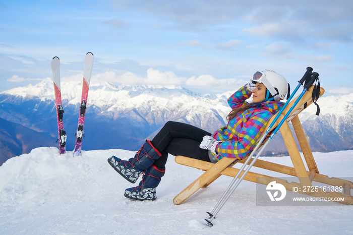 Women at mountains in winter with sun-lounger