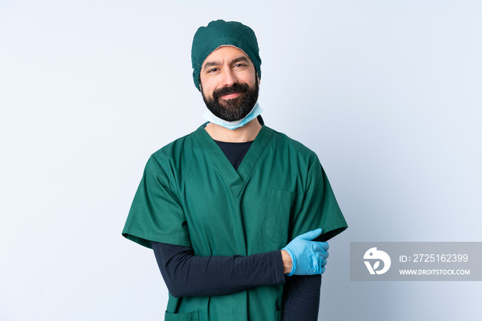 Surgeon man in green uniform over isolated background laughing