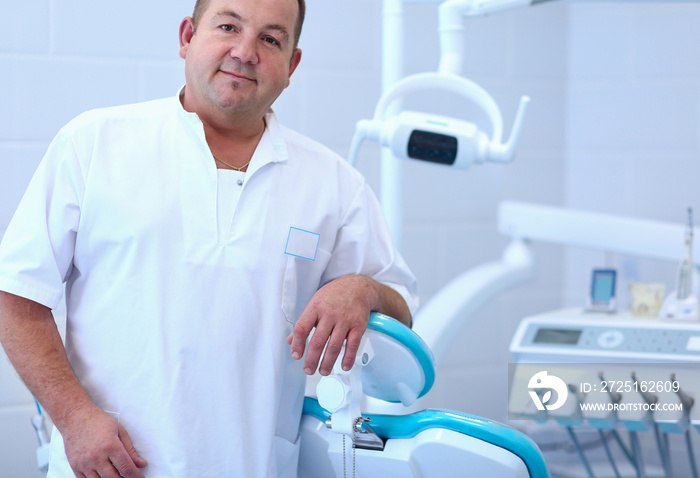 Portrait of a smiling dentist standing in dental clinic