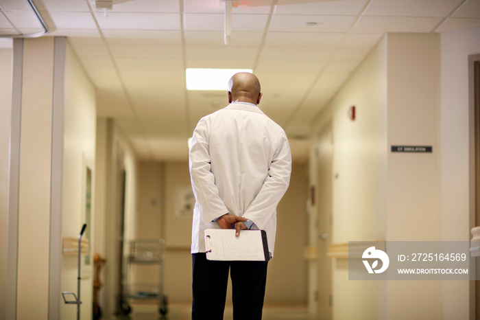 Rear view of doctor walking through corridor