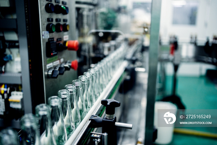 Factory of production and packaging of herbal beverages, Many glass bottles on a conveyor belt enter