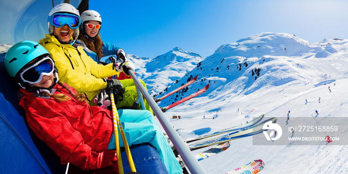 快乐的一家人在滑雪缆车上享受寒假，梅里贝尔，3山谷，法国。玩耍