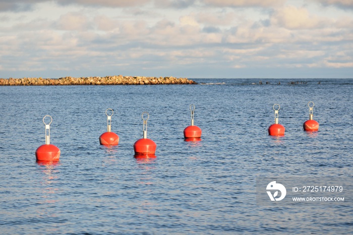 Orange mooring buoys in the new yacht harbor (marina), close-up. Water surface texture. A view from 