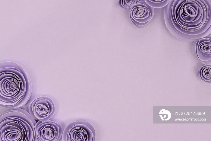 Pastel violet paper craft rose flower flat lay background with flowers on upper right and lower left