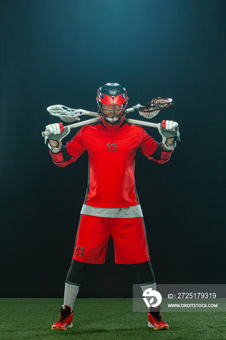 Lacrosse Player, athlete sportsman in red helmet on dark background. Sport and motivation wallpaper.