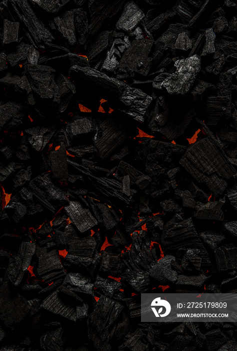 Black charcoal with red streaks of heat. Black textured background.