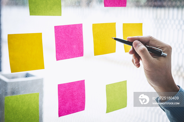 Businessman use post it notes to planning idea and business marketing strategy, Sticky note on glass